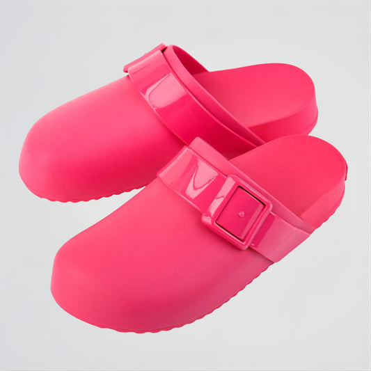 Pair of bright pink clogs with a buckle on a light gray background